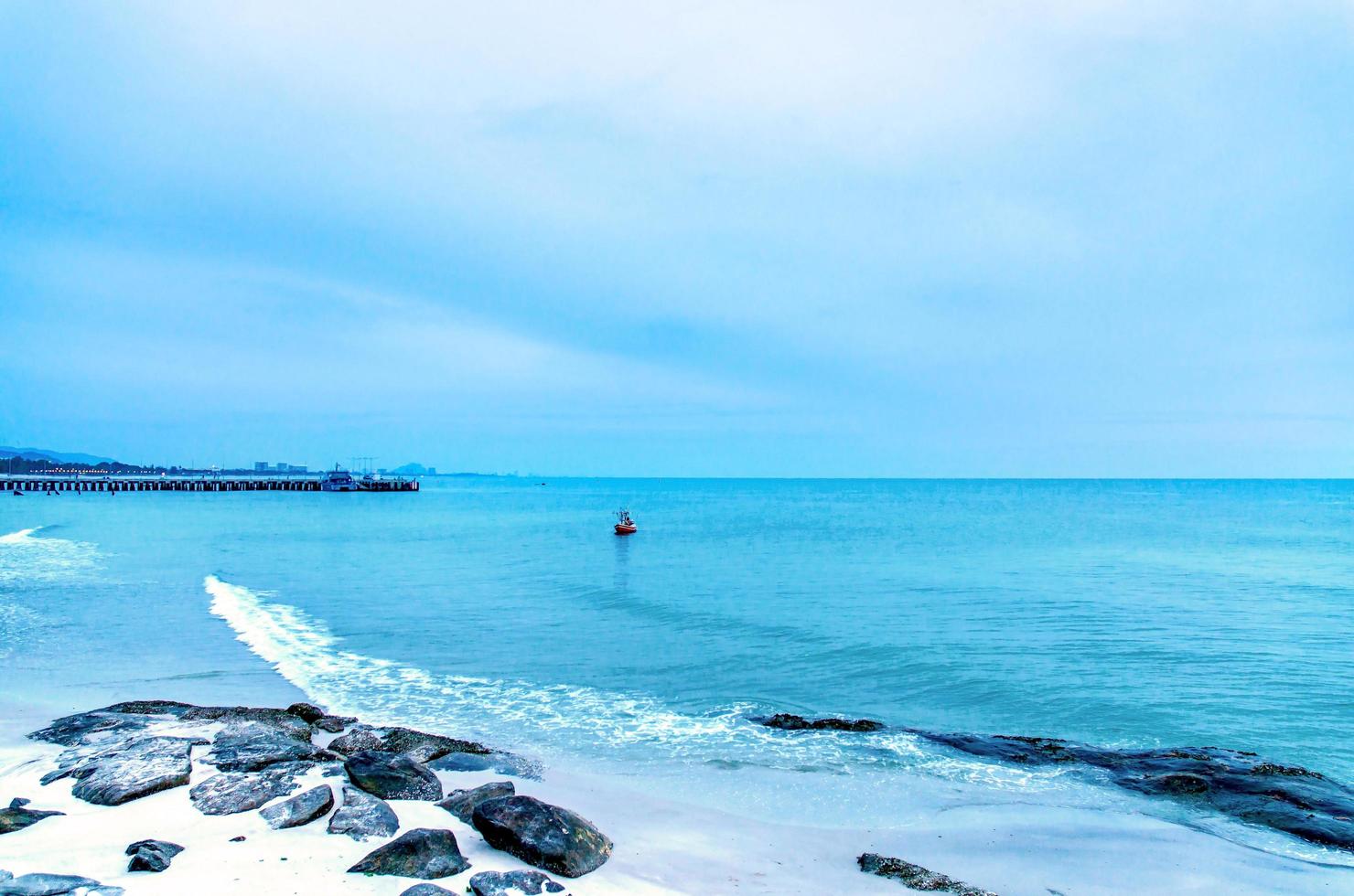 la vista della spiaggia di sabbia e dell'onda del mare con roccia e barriera corallina la mattina? foto