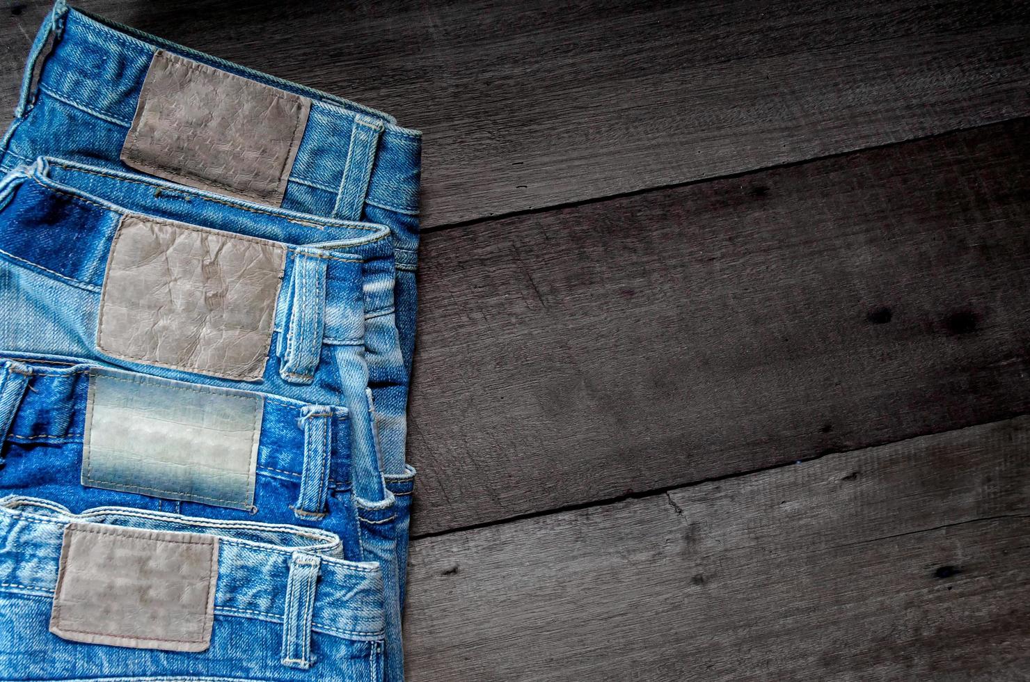 i jeans blu e i jeans mancano di consistenza sul tavolo, i jeans si sovrappongono. foto