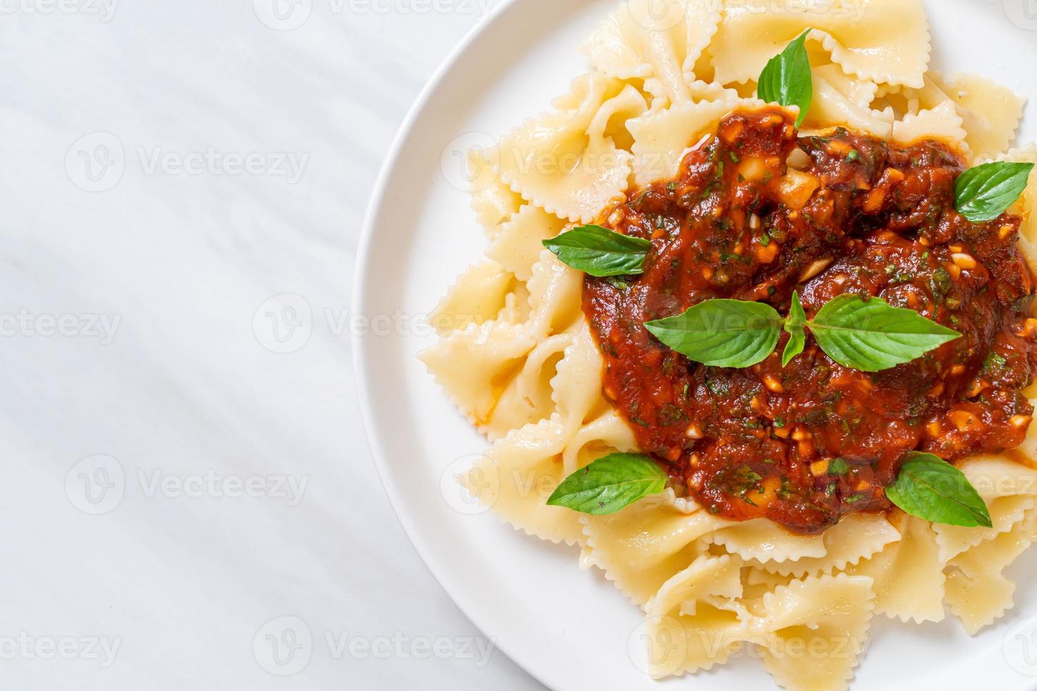 Farfalle al basilico e aglio in salsa di pomodoro foto