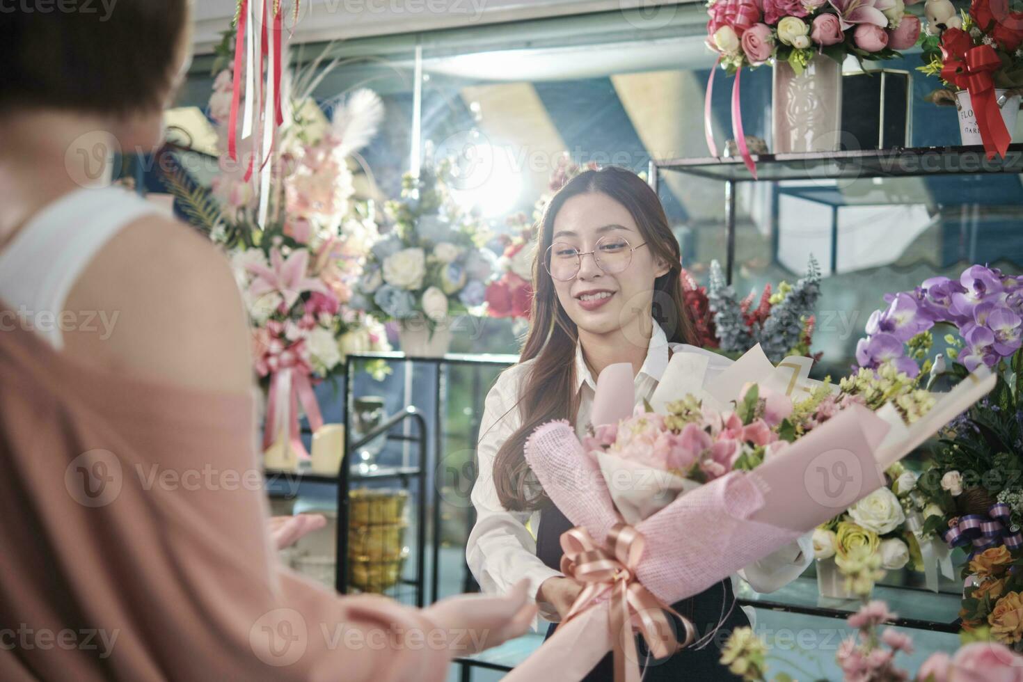 giovane asiatico femmina fioraio lavoratore nel grembiule consegna bellissimo fresco fiori mazzo per cliente chi acquistato ordine, contento venditore chi lavori nel colorato fiore negozio, e piccolo attività commerciale imprenditore. foto