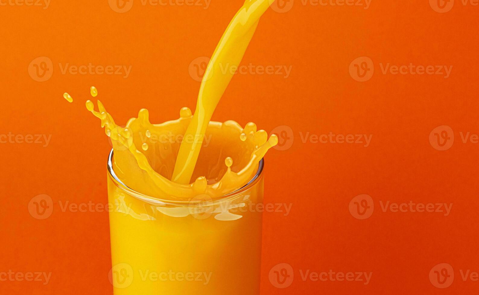 arancia succo scrosciante in bicchiere con spruzzo foto