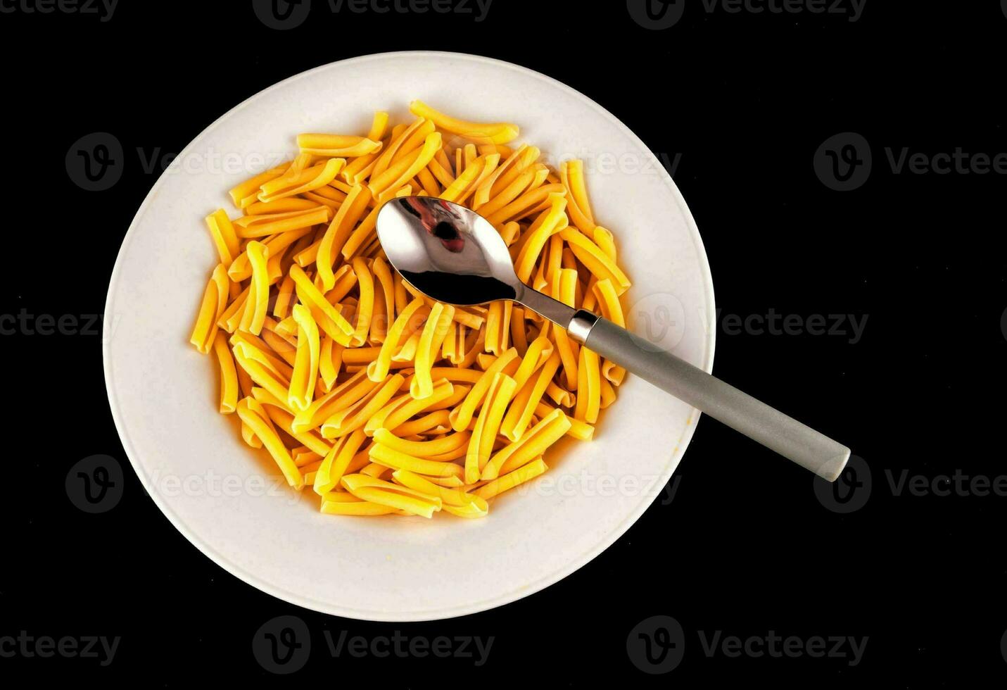 un' bianca piatto pieno con giallo pasta foto