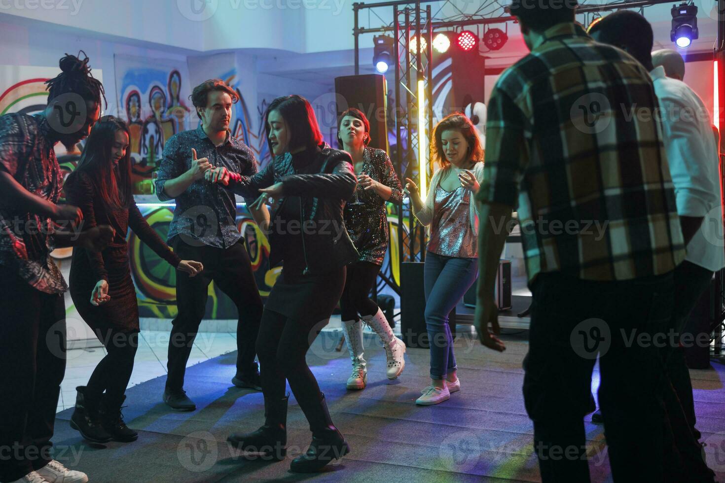 persone partying nel discoteca mentre avendo divertimento e danza su pista da ballo con faretti insieme. giovane uomini e donne folla frequentando discoteca e musica concerto nel club foto