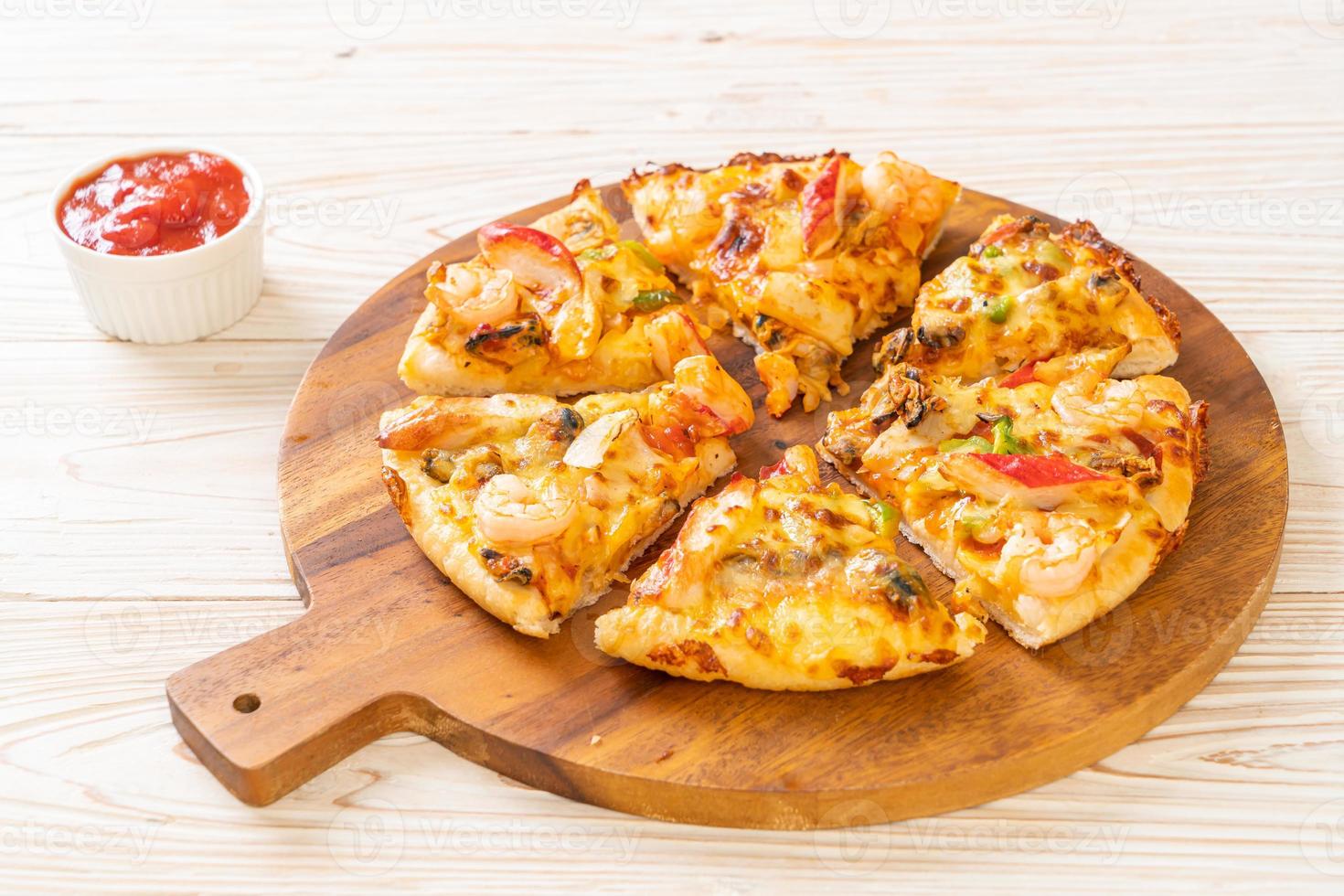 pizza ai frutti di mare sul vassoio di legno foto