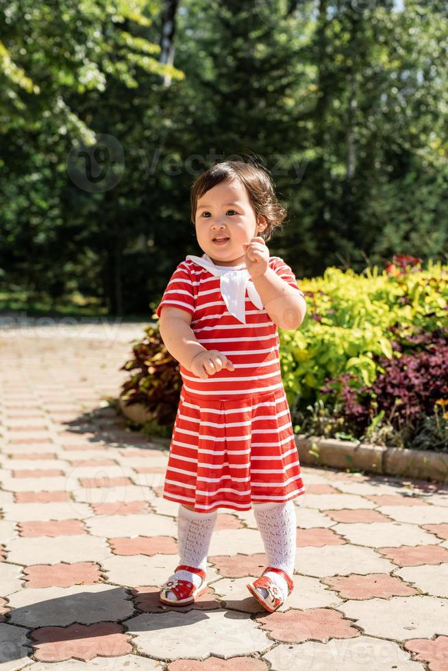 adorabile bambina asiatica che balla nel parco foto