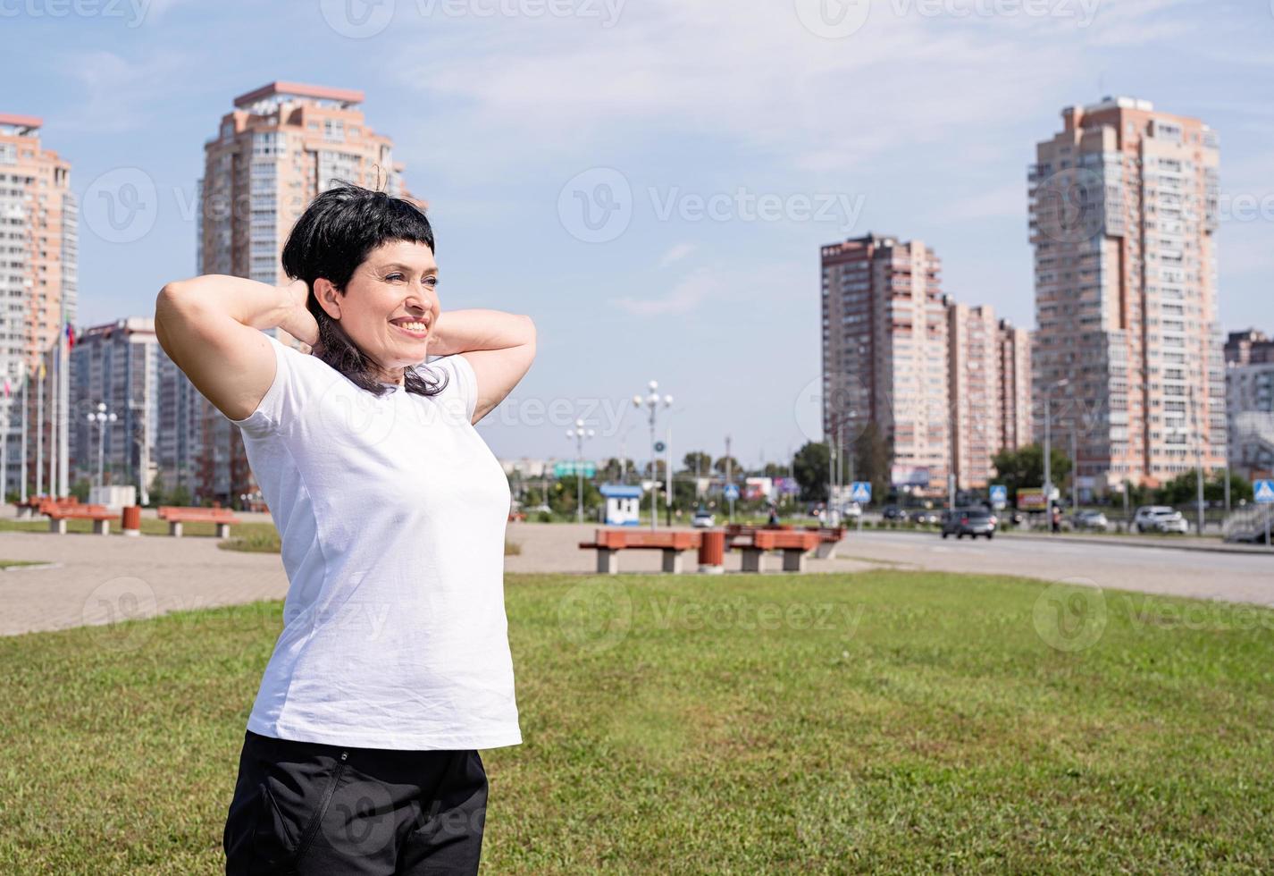 donna che si scalda prima di allenarsi all'aperto nel parco foto