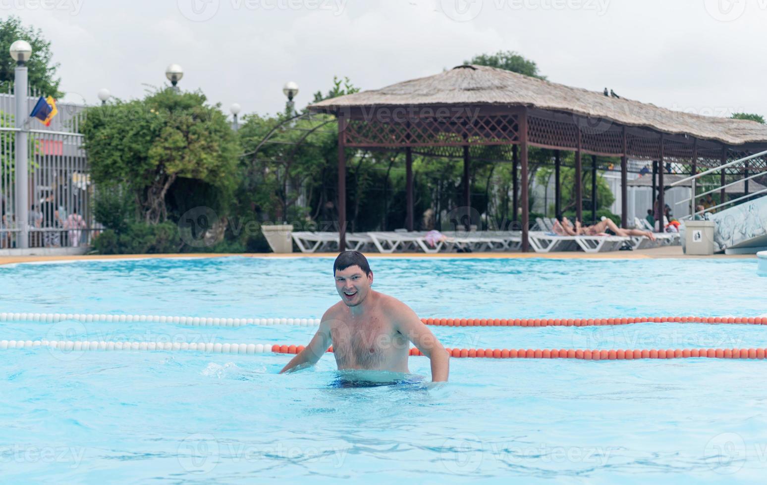 uomo che si diverte a nuotare in piscina nel parco acquatico foto