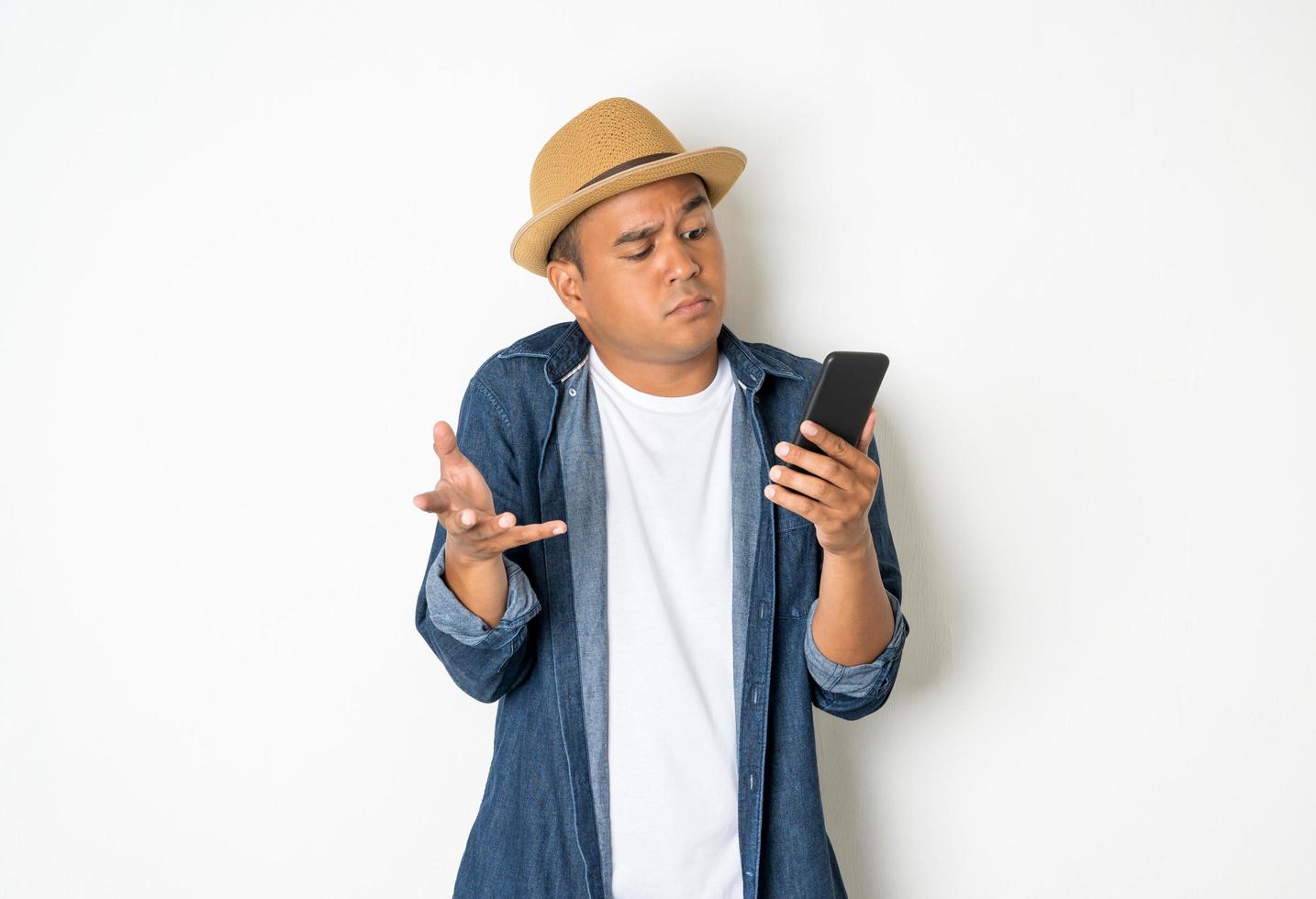 uomo asiatico felice con il suo smartphone su sfondo bianco. foto