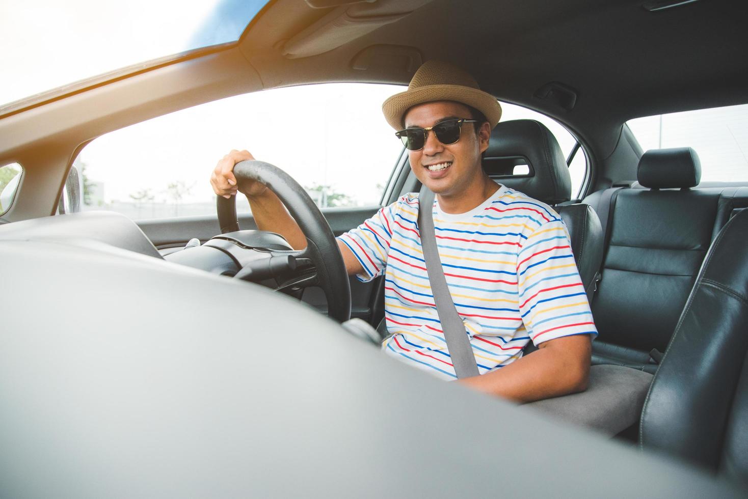 giovane uomo asiatico bello che guida l'auto per viaggiare. foto