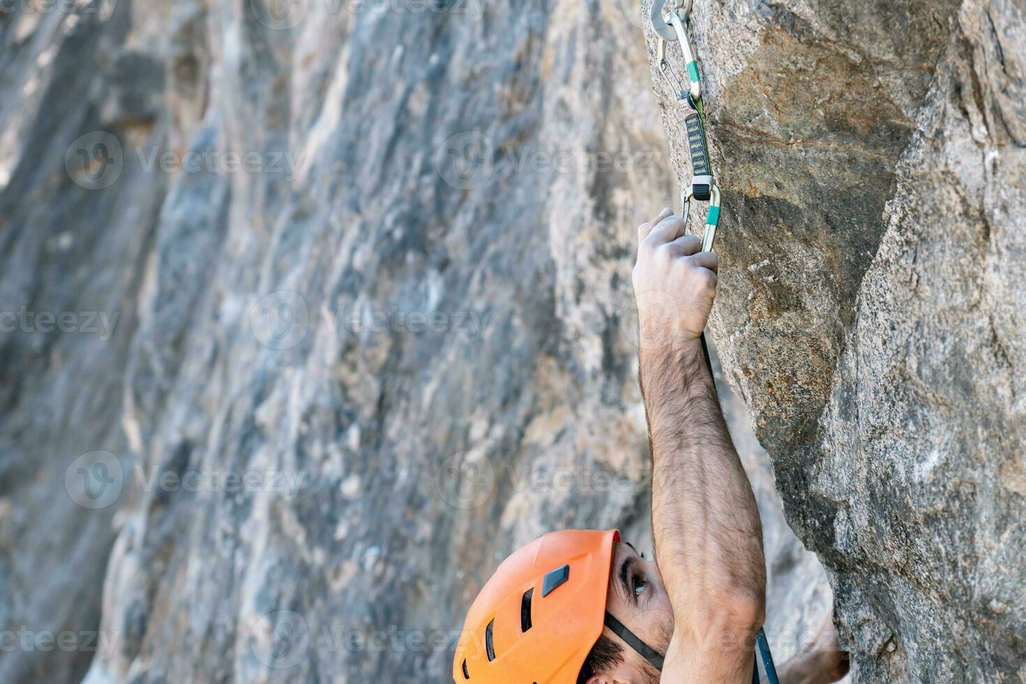 avvicinamento a partire dal sopra, roccia arrampicata utilizzando all'aperto sicurezza imbracatura e casco. foto