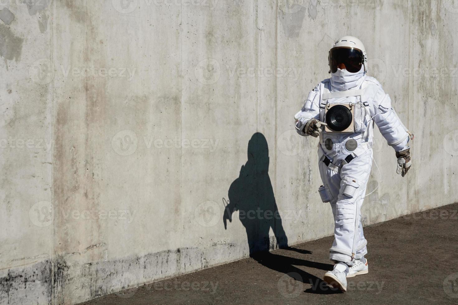 astronauta futuristico con un casco contro le pareti grigie foto
