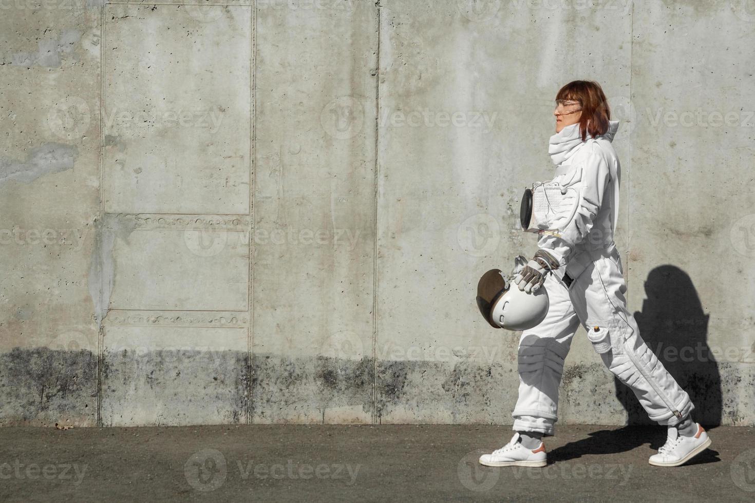 astronauta donna senza casco sullo sfondo di un muro grigio foto