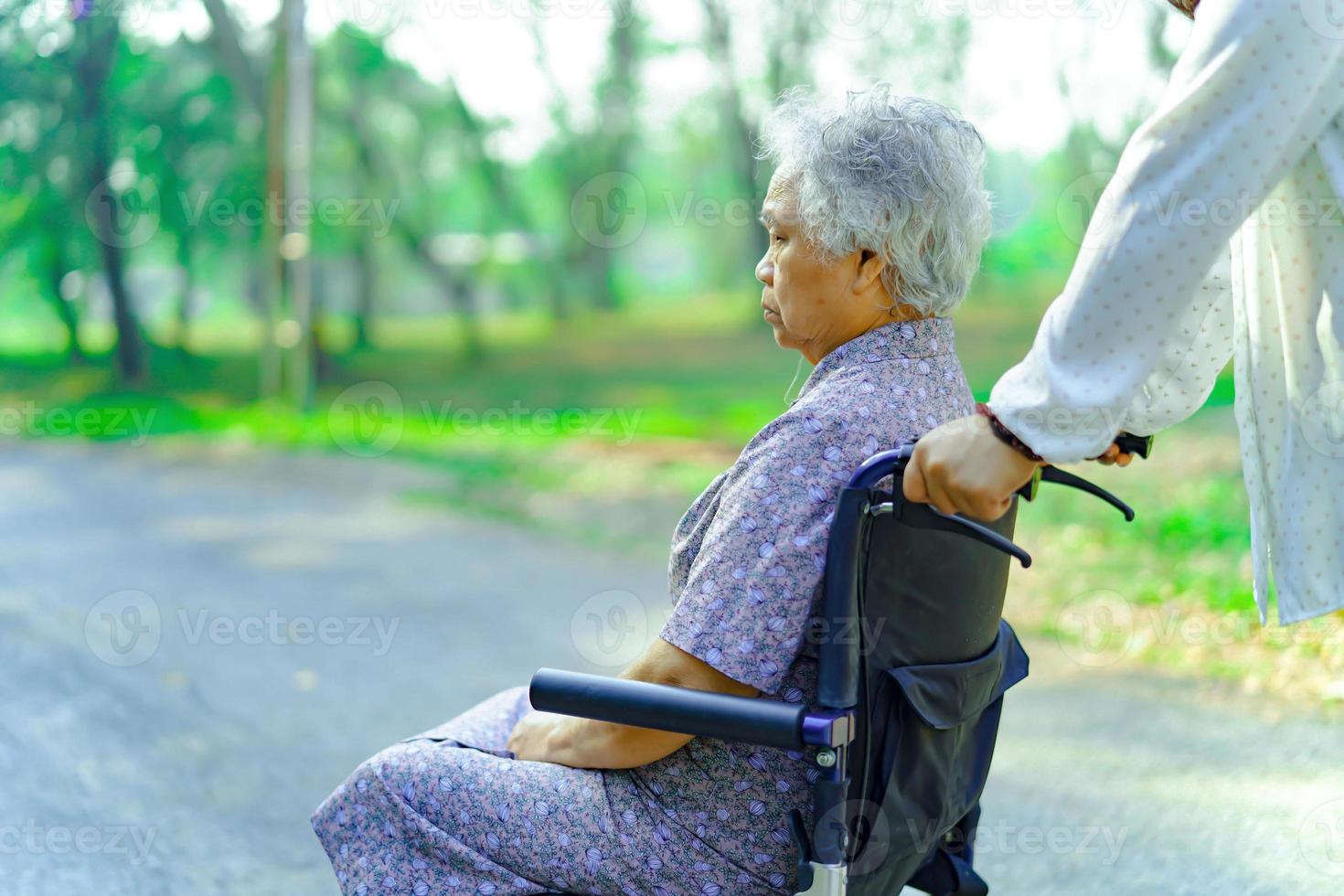 aiutare e curare la donna anziana asiatica usa il camminatore nel parco. foto