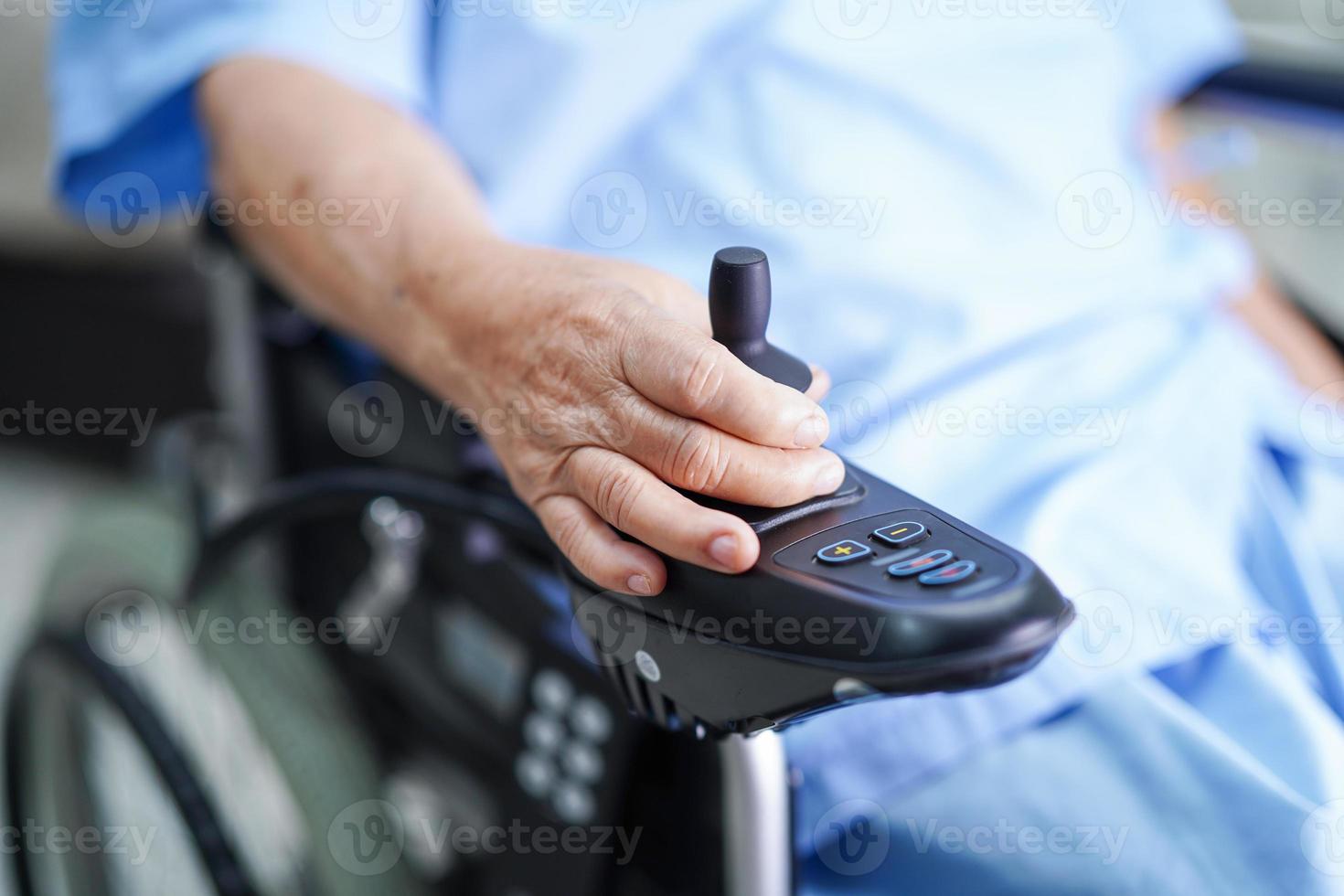 donna anziana asiatica paziente su sedia a rotelle elettrica in ospedale? foto