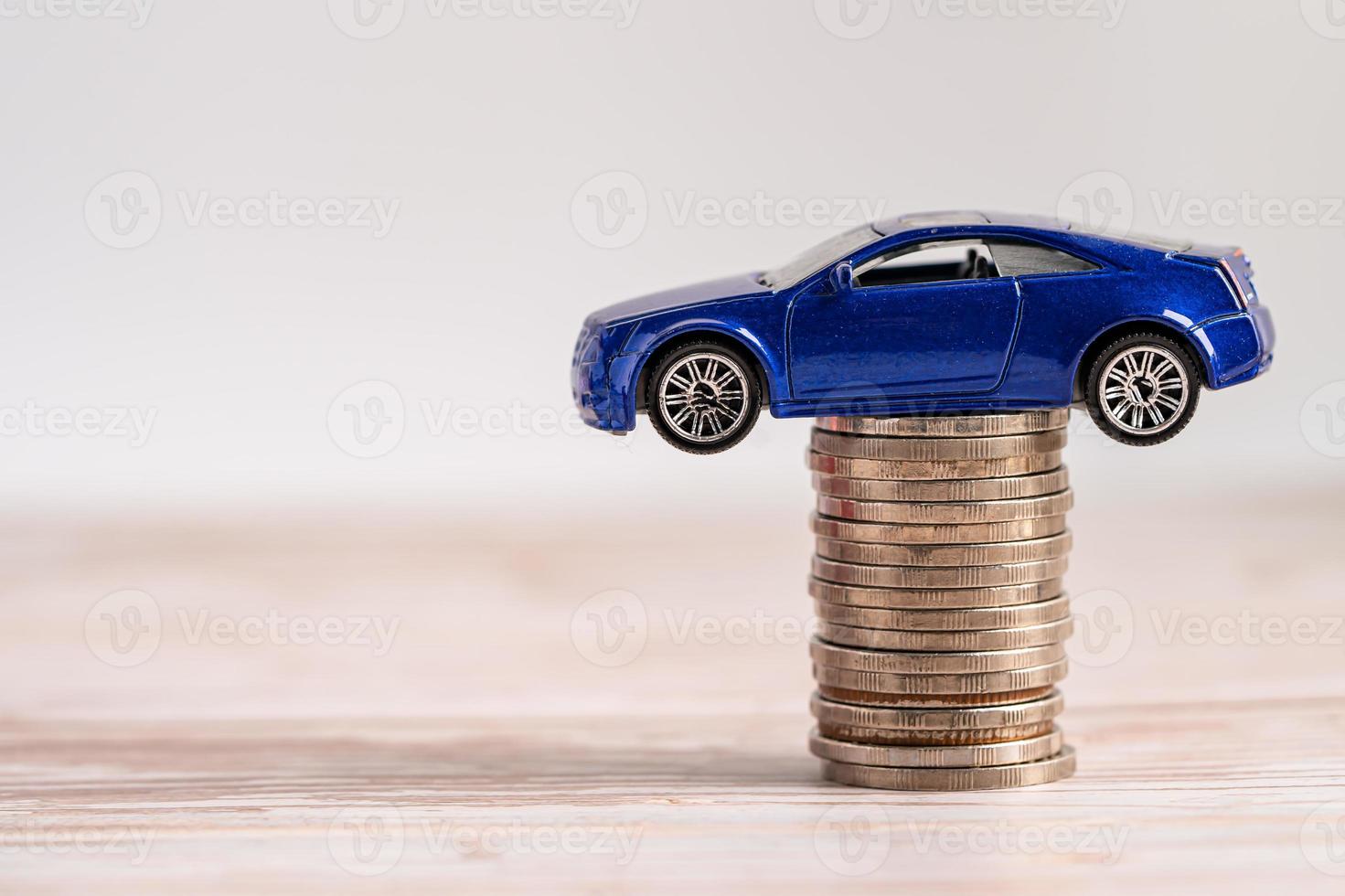 auto sulla pila di monete. prestito auto, assicurazione finanziaria e leasing foto