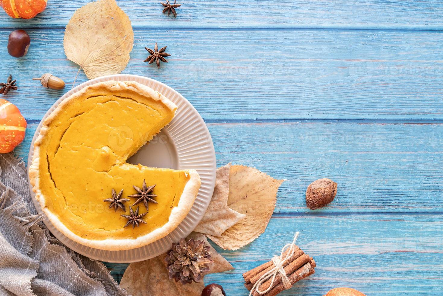 torta di zucca fatta in casa con foglie autunnali su fondo rustico, vista dall'alto foto