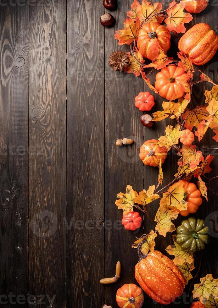 decorazioni autunnali con zucche e foglie vista dall'alto su legno nero foto