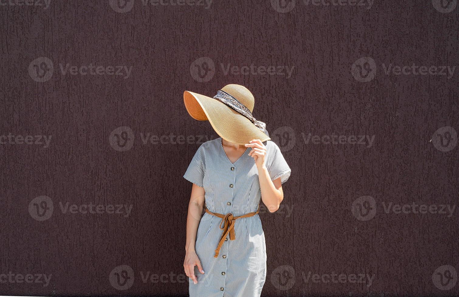 ritratto di una bella donna in elegante cappello estivo sul muro viola foto