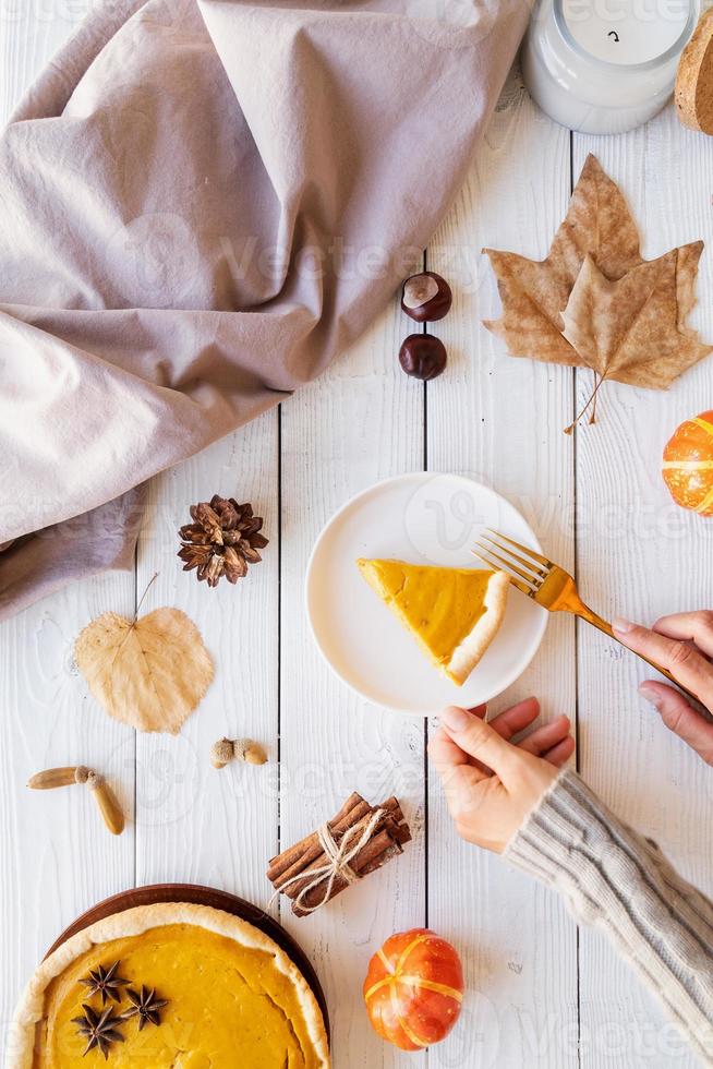 torta di zucca fatta in casa con foglie autunnali su fondo rustico, vista dall'alto foto