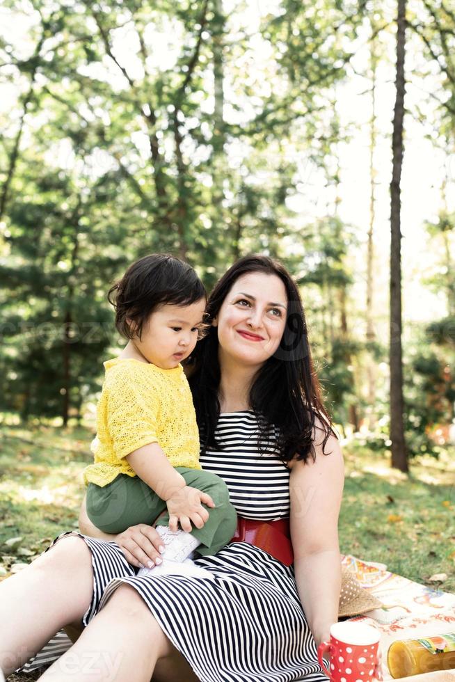 famiglia multirazziale di madre e figlia nel parco durante un picnic foto