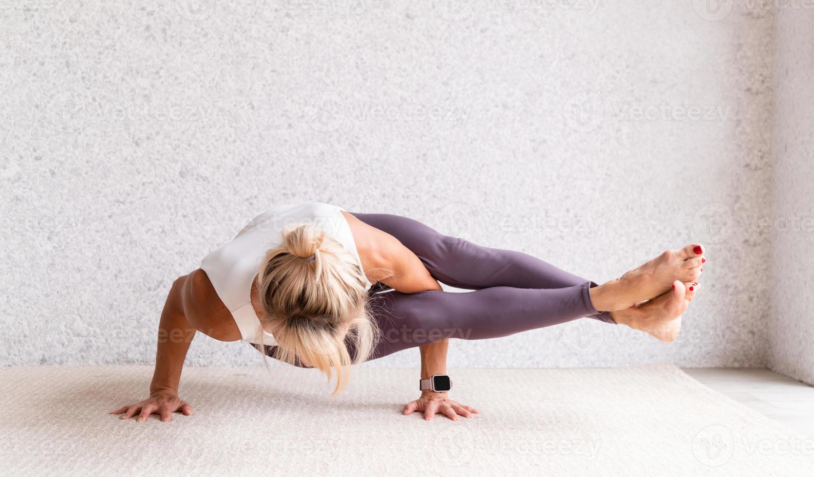 giovane donna attraente che pratica yoga, indossando abbigliamento sportivo, foto