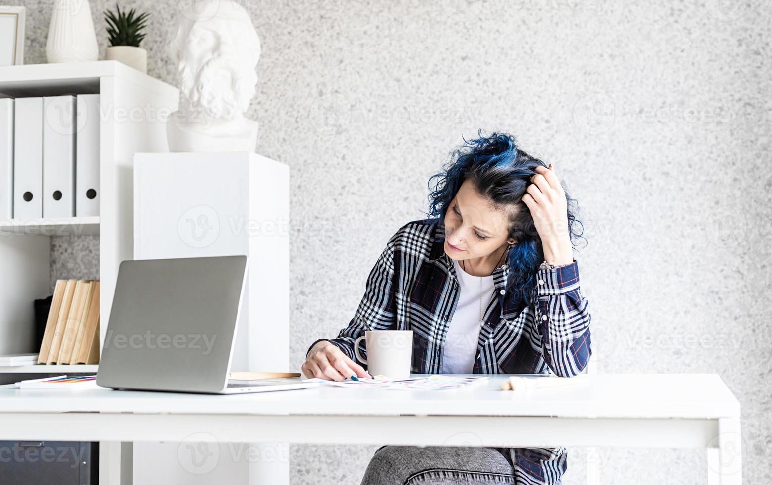 designer che lavora con tavolozze di colori e laptop nel suo studio foto