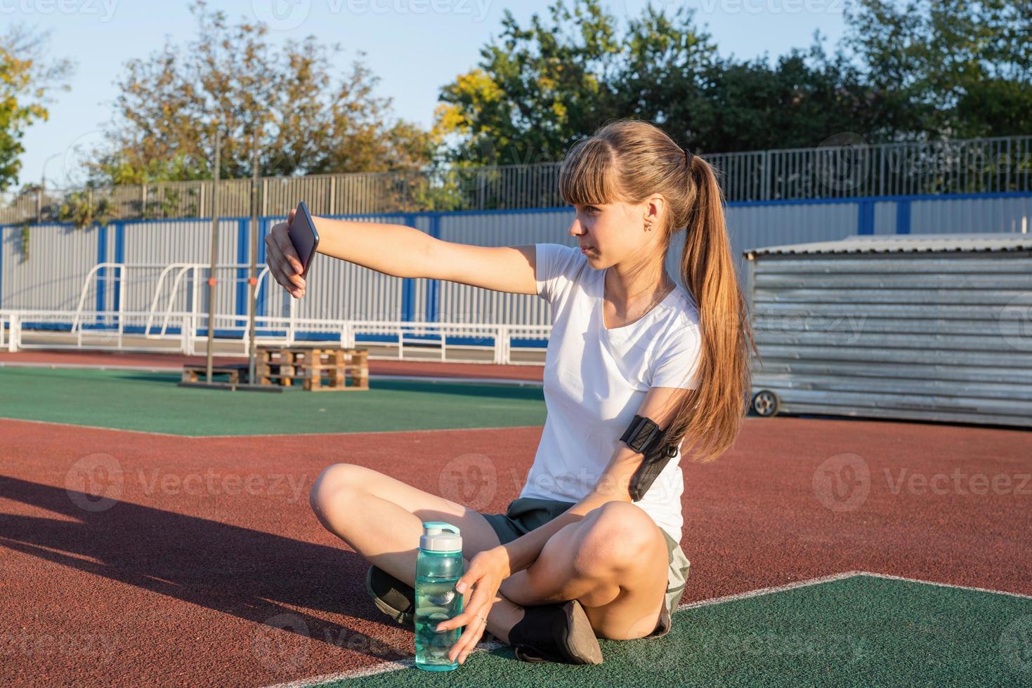 ragazza adolescente che fa selfie allo stadio dopo l'allenamento foto