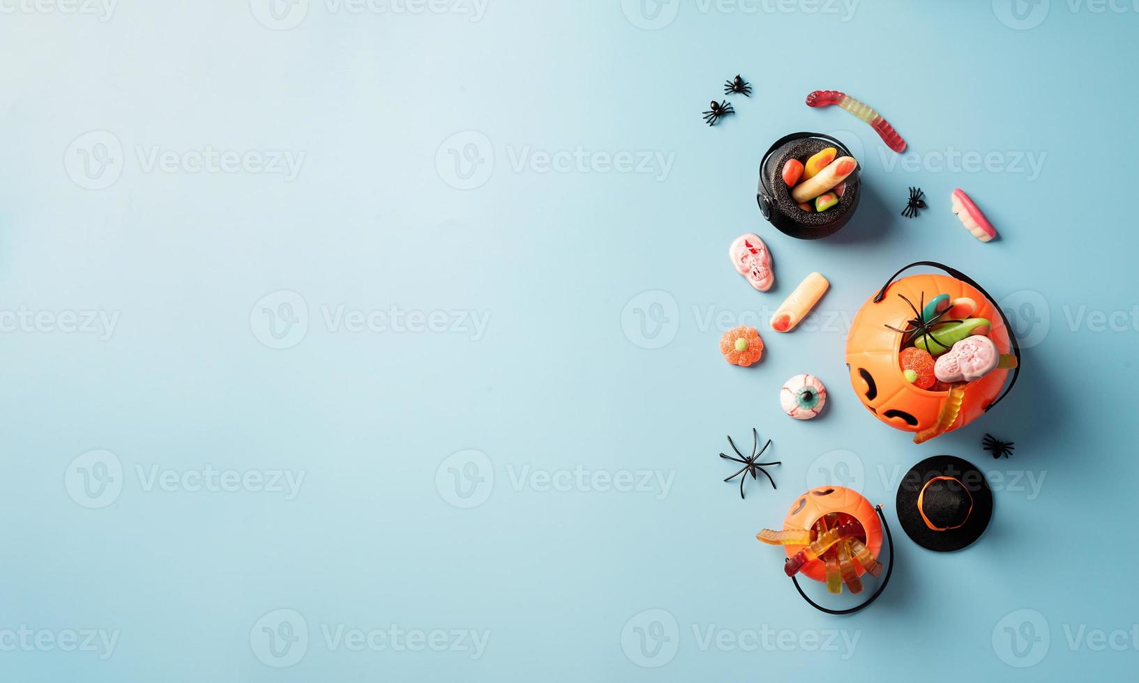 vari dolci e caramelle di halloween in un vaso di zucca, vista dall'alto foto