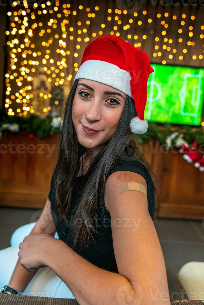 ritratto di un' giovane femmina sorridente dopo ottenere un' vaccino - donna mostrando sua braccio con gesso durante un' Natale festa foto