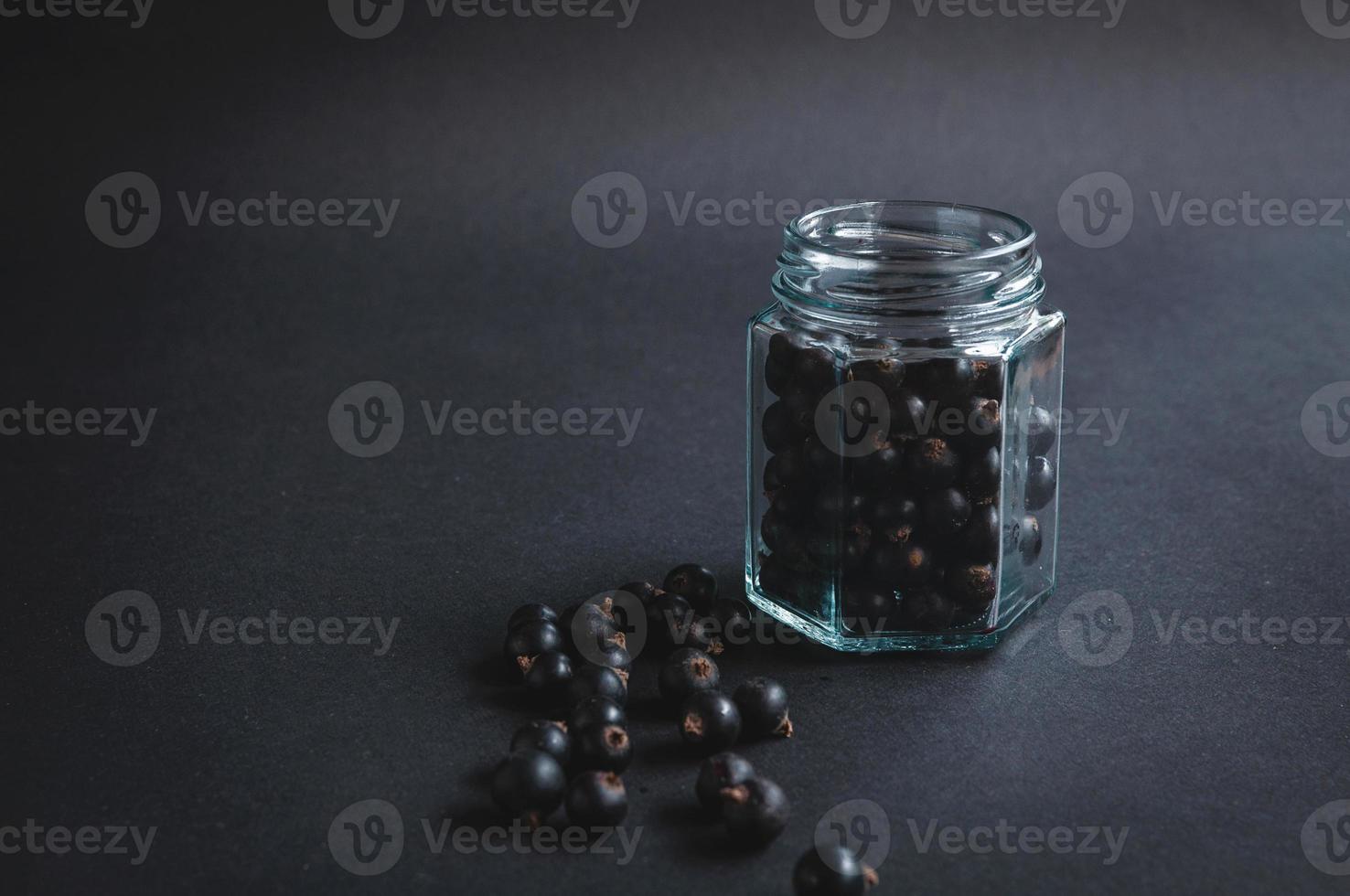 vaso di vetro con bacche di ribes su sfondo nero. foto