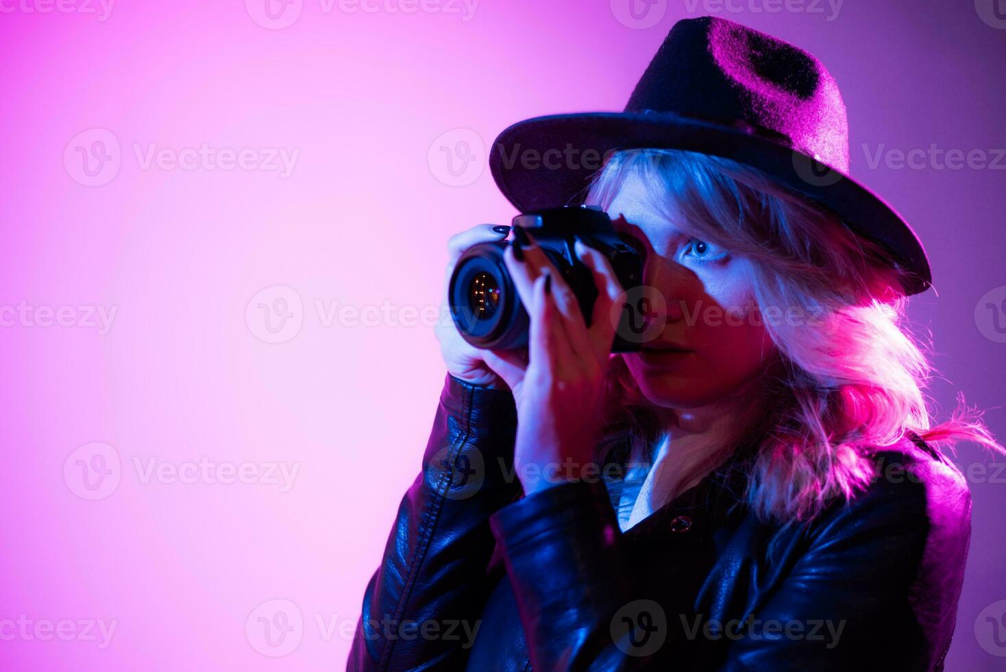 ritratto di un' bellissimo ragazza fotografo nel un' cappello chi prende immagini nel il studio su un' filetto sfondo foto