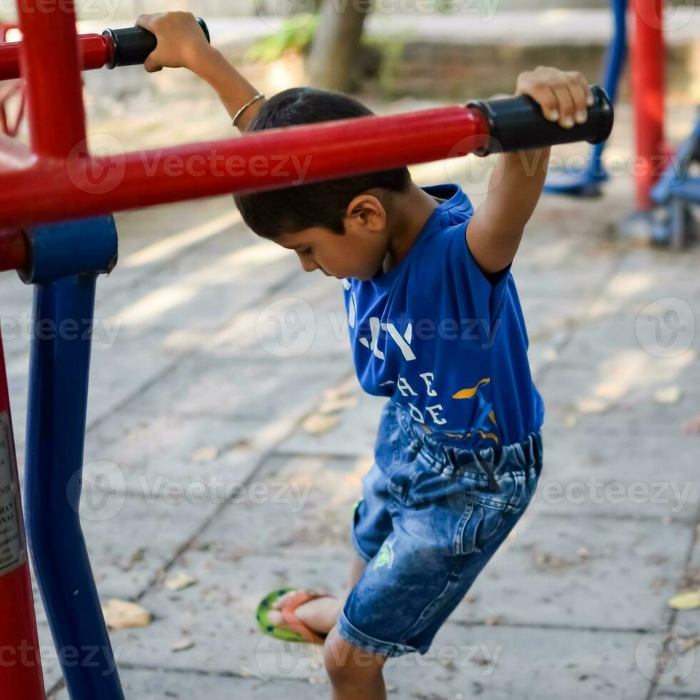 asiatico ragazzo fare routine esercizio nel società parco durante il mattina volta. carino poco ragazzo esercizio e Palestra per mantenere lui stesso in forma per vita. bambino esercizio all'aperto sparare foto