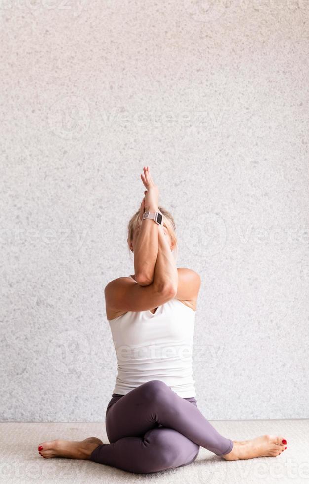 giovane donna attraente che pratica yoga, indossando abbigliamento sportivo foto