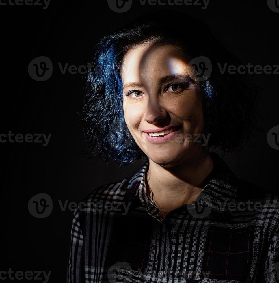 ritratto di una bella donna con i capelli tinti di blu con un motivo di ombre sul viso foto