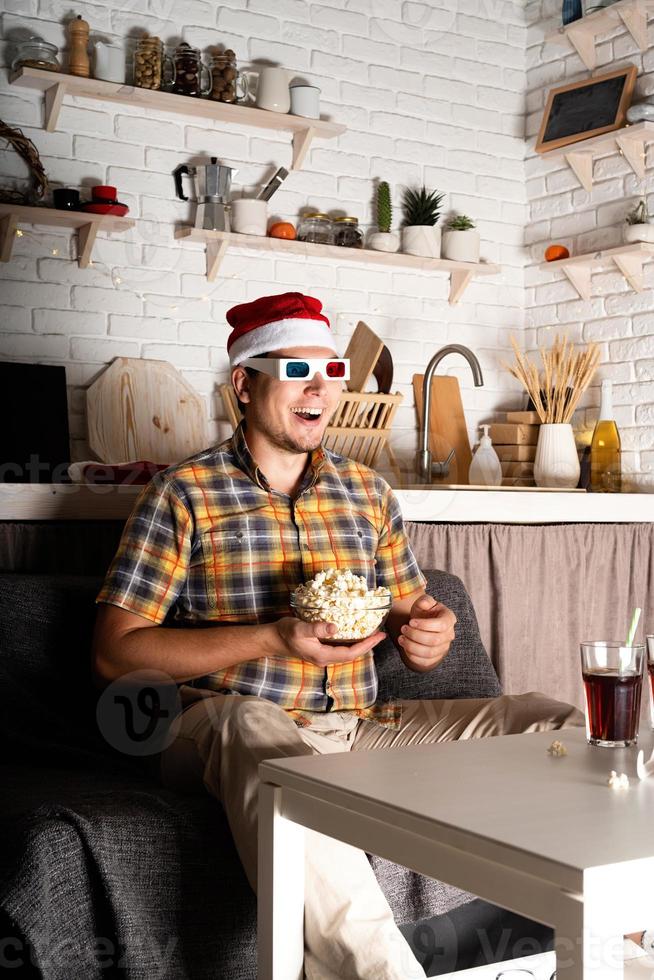 giovane uomo con gli occhiali 3d che guarda film a casa di notte a natale foto