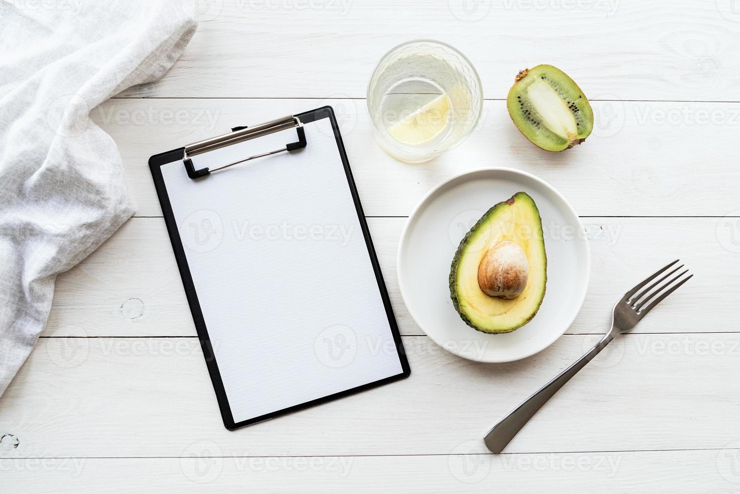 piano di disintossicazione di avocado e kiwi e blocco note vuoto, vista dall'alto piatta foto