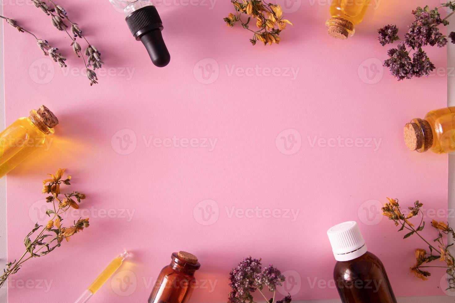 erbe secche e bottiglie di olio o tintura vista dall'alto foto