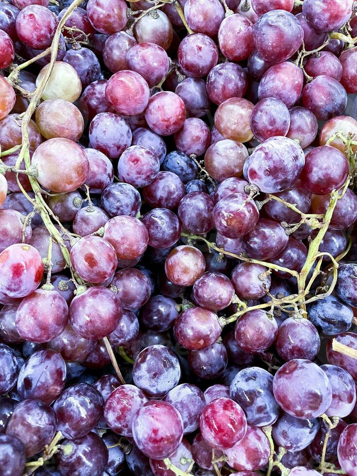 vicino su di crudo biologico dolce rosso uva sfondo, vino uva struttura, salutare frutta rosso vino uva sfondo, superiore Visualizza foto