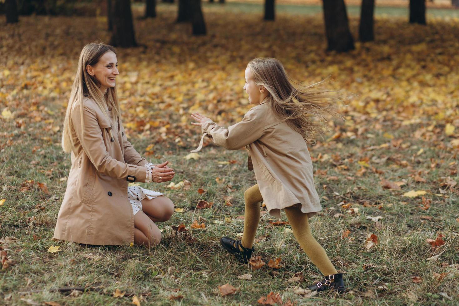 madre e figlia si divertono e camminano nel parco autunnale. foto