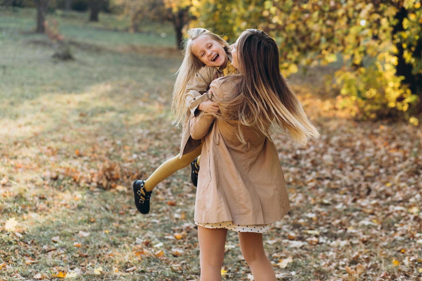 madre e figlia si divertono e camminano nel parco autunnale. foto