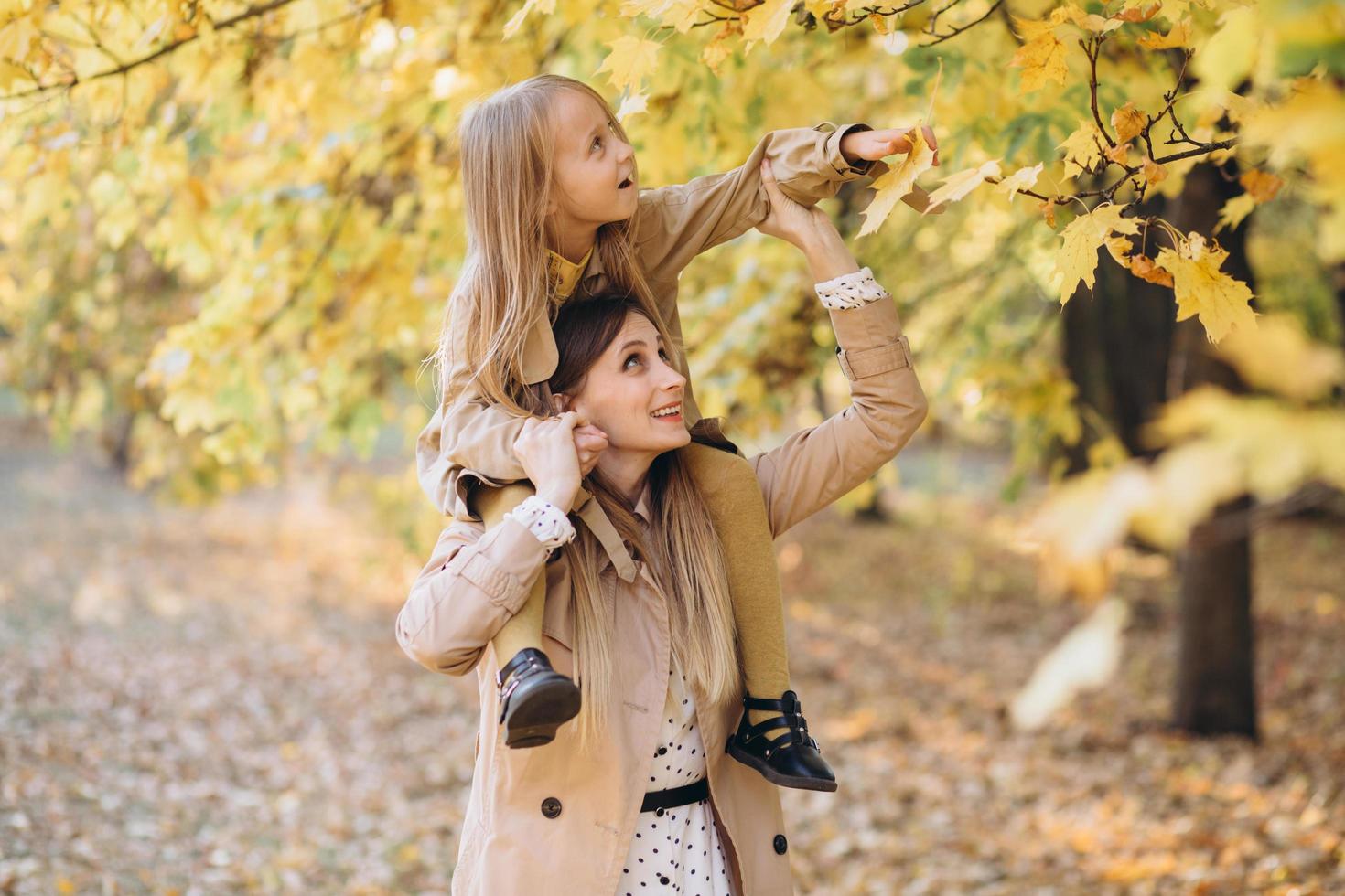 madre e figlia si divertono e camminano nel parco autunnale. foto