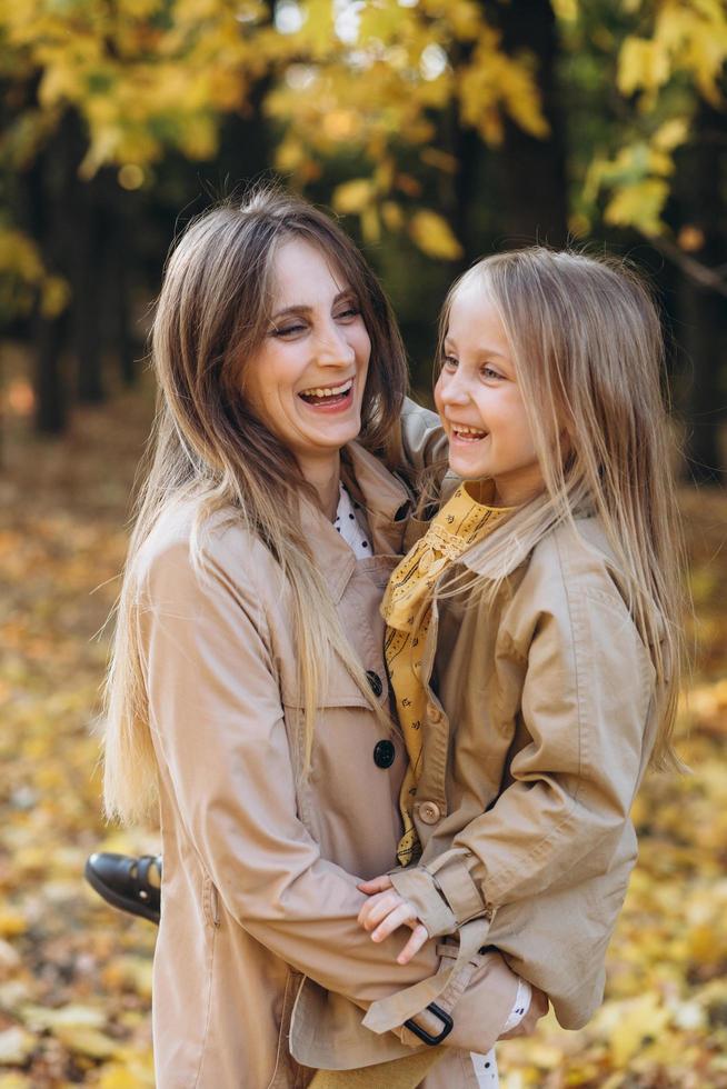 madre e figlia si divertono e camminano nel parco autunnale. foto