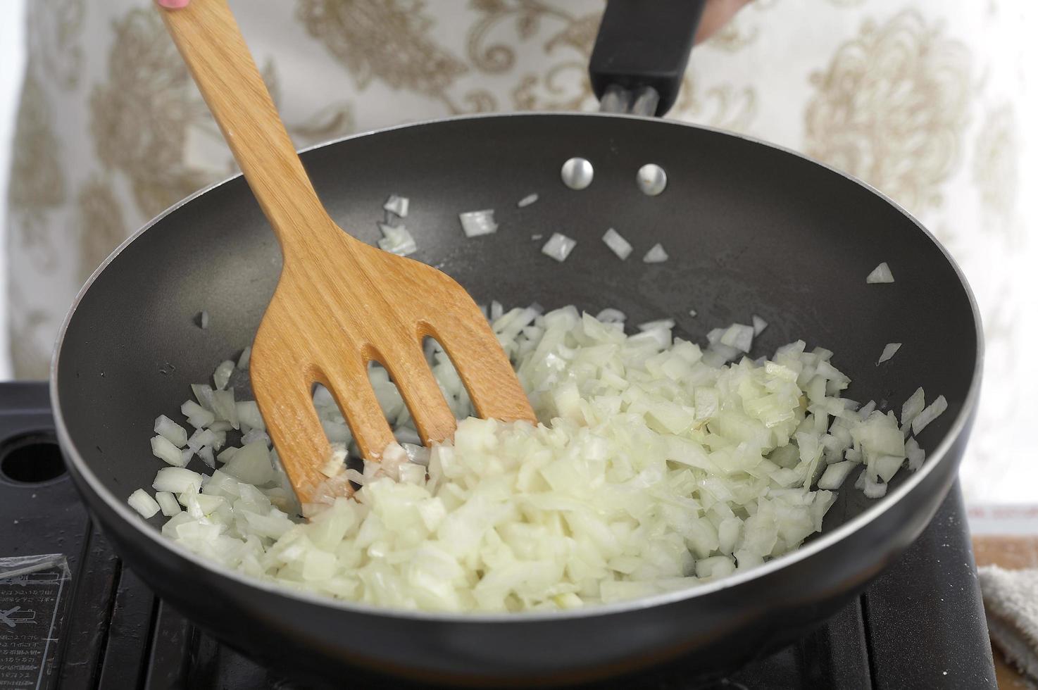 cipolla soffriggere con olio d'oliva in padella nera foto