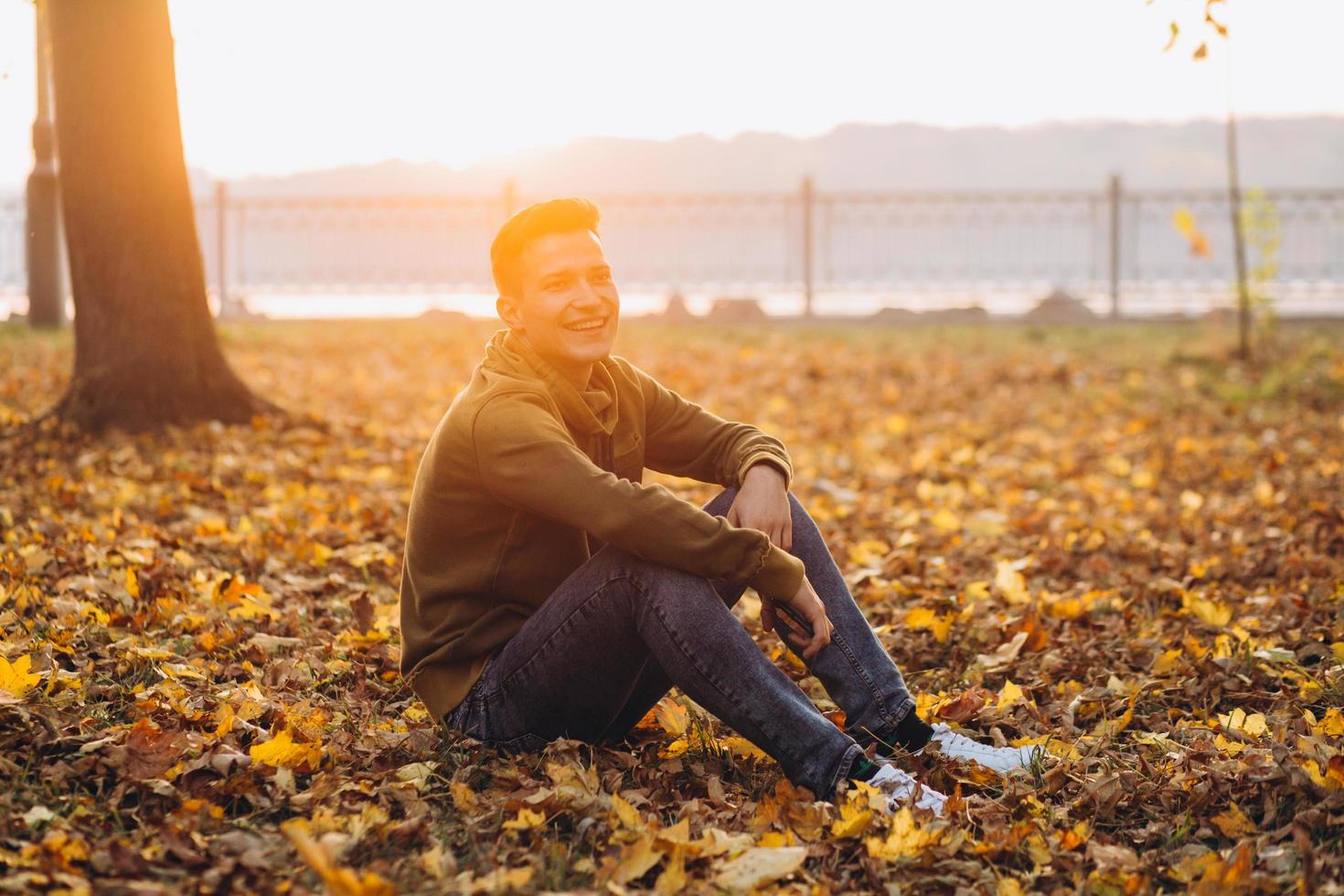 ragazzo bello e felice che sorride nel parco autunnale foto