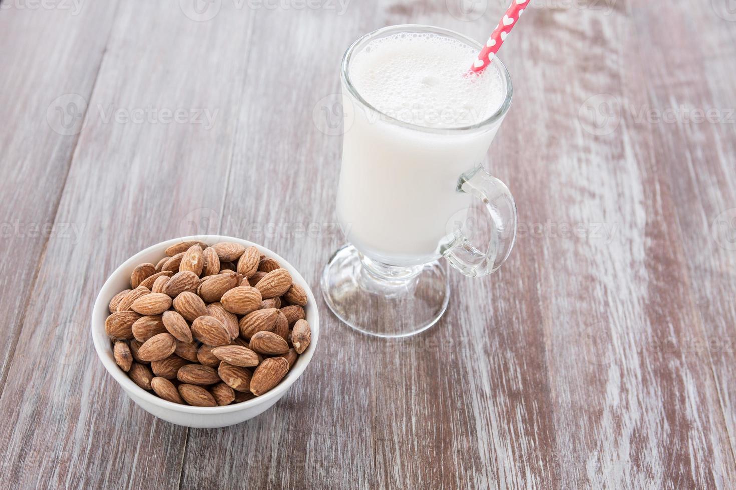 ciotola di mandorle e bicchiere di latte di mandorle foto