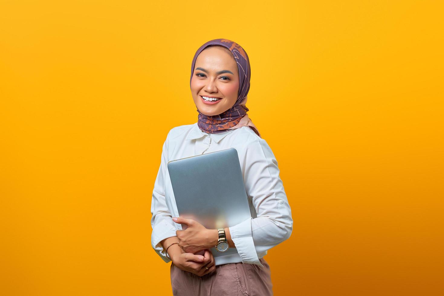 il ritratto della donna asiatica sorridente porta il computer portatile? foto