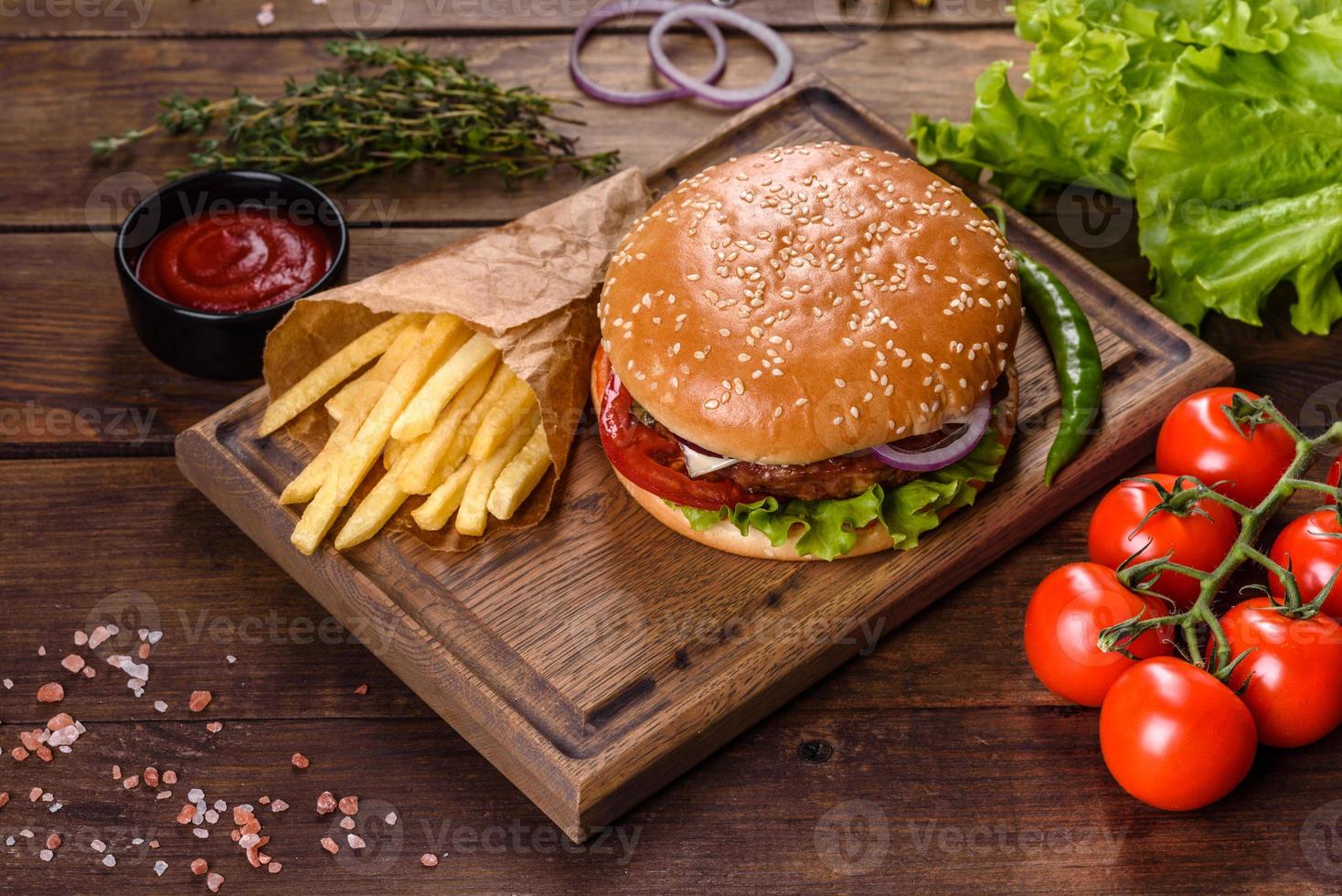 hamburger di manzo artigianale e patatine fritte su sfondo nero foto