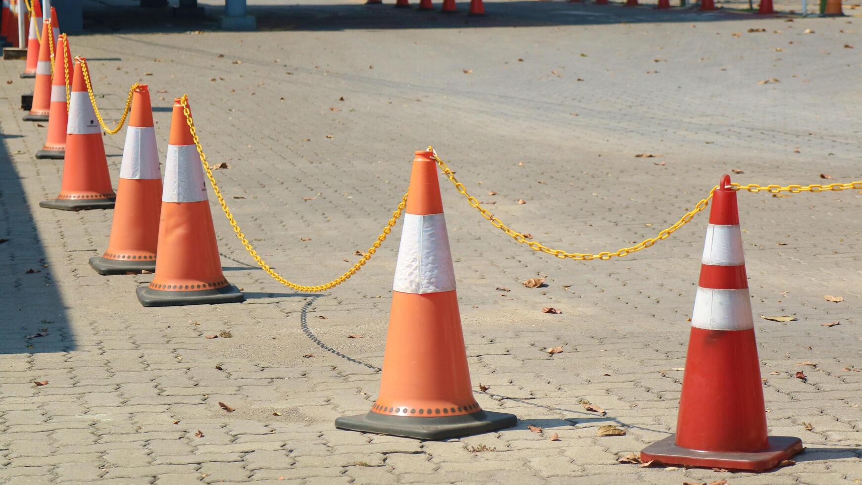 cono stradale sulla strada asfaltata danneggiata foto