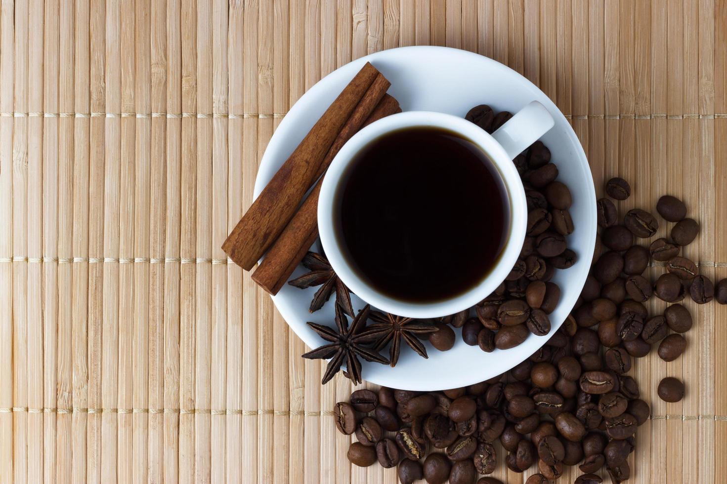 tazza di caffè bianca con anice e bastoncini di cannella foto