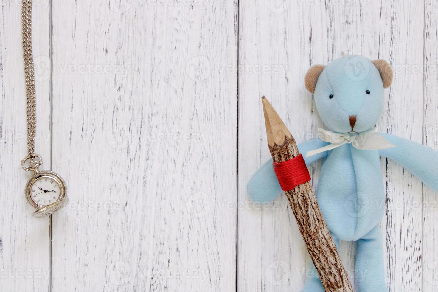 tavolo in legno dipinto di bianco bambola orso blu con orologio da tasca a matita foto